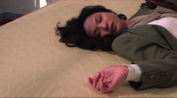 Movie still from “Vive L'Amour” (1994), directed by Tsai Ming-liang – A woman laying on a bed next to a hand; Close Up shot, Overhead angle