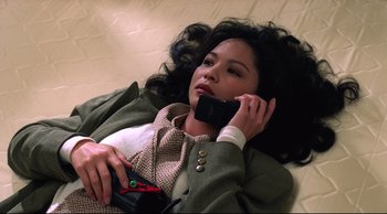 Movie still from “Vive L'Amour” (1994), directed by Tsai Ming-liang – A woman laying on the ground talking on a cell phone; Close Up shot, High angle