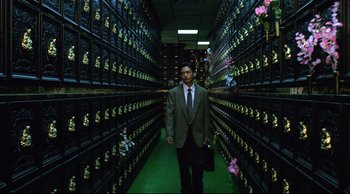 A man in a suit and tie in a room filled with cabinets