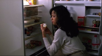 Movie still from “Vive L'Amour” (1994), directed by Tsai Ming-liang – A woman eating a sandwich in a refrigerator; Medium shot, High angle