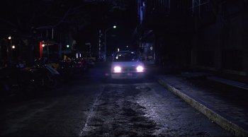 Movie still from “Vive L'Amour” (1994), directed by Tsai Ming-liang – A car driving down a street at night; Extreme Wide shot, High angle