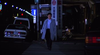 Movie still from “Vive L'Amour” (1994), directed by Tsai Ming-liang – A man is crossing the street at night; Wide shot, Low angle