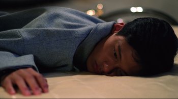 Movie still from “Vive L'Amour” (1994), directed by Tsai Ming-liang – A man laying on a bed with his eyes closed; Close Up shot, Overhead angle