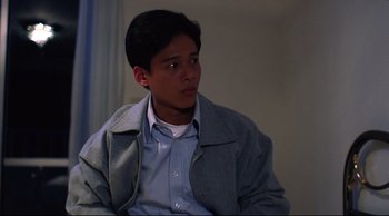 Movie still from “Vive L'Amour” (1994), directed by Tsai Ming-liang – A young man sitting in front of a window; Close Up shot, High angle