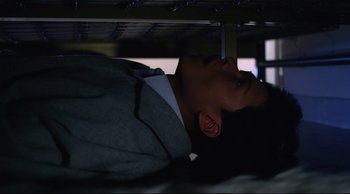 Movie still from “Vive L'Amour” (1994), directed by Tsai Ming-liang – A man in a suit laying on a bed; Close Up shot, Overhead angle