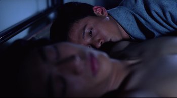 Movie still from “Vive L'Amour” (1994), directed by Tsai Ming-liang – A man and a woman laying in a bed together; Close Up shot, Overhead angle