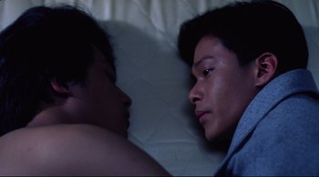 Movie still from “Vive L'Amour” (1994), directed by Tsai Ming-liang – Two people sleeping in a bed with one of them looking at the other; Close Up shot, Overhead angle