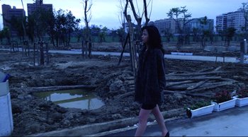 Movie still from “Vive L'Amour” (1994), directed by Tsai Ming-liang – A woman walking down the street at night; Wide shot, High angle