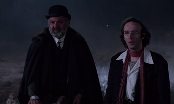 Movie still from “Voice of the Moon” (1990), directed by Richard Stanley – A man and a woman standing next to each other in the dark; Medium shot, Low angle