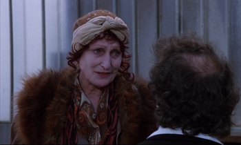 Movie still from “Voice of the Moon” (1990), directed by Richard Stanley – An older woman wearing a turban talking to another woman; Close Up shot, Over the shoulder angle