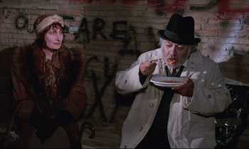 Movie still from “Voice of the Moon” (1990), directed by Richard Stanley – An older man eating a plate of food next to an older woman; Medium shot, Over the shoulder angle