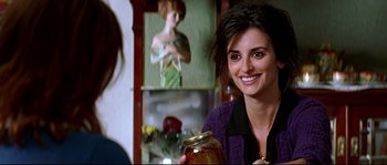 Movie still from “Volver” (2006), directed by Pedro Almodóvar – A woman smiles while holding a jar of pickles; Close Up shot, Over the shoulder angle