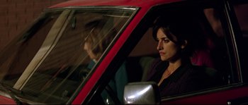 Movie still from “Volver” (2006), directed by Pedro Almodóvar – A woman sitting in the driver's seat of a red car; Medium shot, Over the shoulder angle