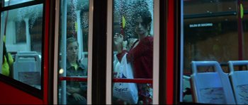 Movie still from “Volver” (2006), directed by Pedro Almodóvar – A woman holding onto a bag while looking out a window; Medium shot, Low angle