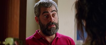 Movie still from “Volver” (2006), directed by Pedro Almodóvar – A man with grey hair and a beard stares at the camera; Close Up shot, Over the shoulder angle