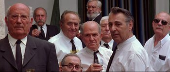 Movie still from “Volver” (2006), directed by Pedro Almodóvar – A group of men in white shirts and black ties; Medium shot, Over the shoulder angle