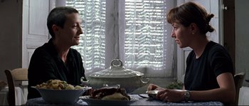 Movie still from “Volver” (2006), directed by Pedro Almodóvar – Two people sitting at a table with a pie in front of them; Close Up shot, Over the shoulder angle