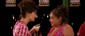 Movie still from “Volver” (2006), directed by Pedro Almodóvar – Two women are having a conversation while holding a drink; Close Up shot, Over the shoulder angle