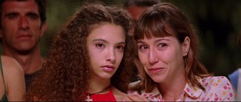 Movie still from “Volver” (2006), directed by Pedro Almodóvar – Two young women pose for a picture together; Close Up shot, Low angle