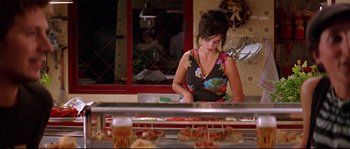 Movie still from “Volver” (2006), directed by Pedro Almodóvar – A woman standing in front of a counter with food on top of it; Medium shot, Over the shoulder angle