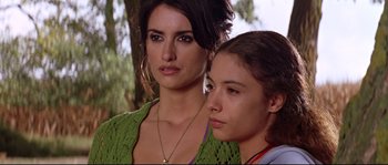 Movie still from “Volver” (2006), directed by Pedro Almodóvar – Two young women standing next to each other in front of a tree; Close Up shot, Low angle