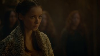 Movie still from “Game of Thrones” (2011), created by D.B. Weiss – A woman with a scarf looking at the camera; Close Up shot, Over the shoulder angle