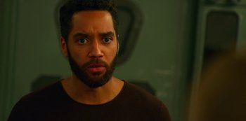 Movie still from “Another Life” (2019), created by Aaron Martin – A person with a beard looking at the camera; Close Up shot, Over the shoulder angle