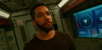 Movie still from “Another Life” (2019), created by Aaron Martin – A person with a beard looking at the camera; Close Up shot, High angle