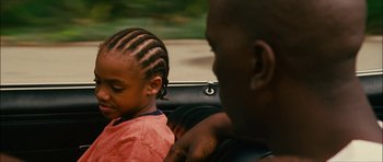 Movie still from “Waist Deep” (2006), directed by Vondie Curtis-Hall – A man and a child in the back seat of a car; Close Up shot, Over the shoulder angle