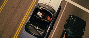 Movie still from “Waist Deep” (2006), directed by Vondie Curtis-Hall – Two people in the back of a car on the road; Wide shot, Overhead angle