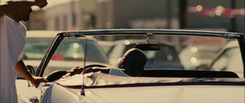 Movie still from “Waist Deep” (2006), directed by Vondie Curtis-Hall – A person is sitting in the back seat of a car; Wide shot, Over the shoulder angle
