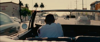 Movie still from “Waist Deep” (2006), directed by Vondie Curtis-Hall – A man sitting in the driver's seat of a car driving down a street; Medium shot, Over the shoulder angle