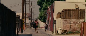 Movie still from “Waist Deep” (2006), directed by Vondie Curtis-Hall – Two people running down the street in a city; Extreme Wide shot, High angle
