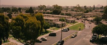 Movie still from “Waist Deep” (2006), directed by Vondie Curtis-Hall – An aerial view of an apartment complex with cars parked on the side of the road; Extreme Wide shot, High angle