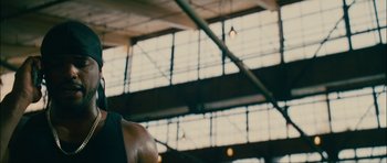 Movie still from “Waist Deep” (2006), directed by Vondie Curtis-Hall – A man is standing in a gym with his arms crossed; Close Up shot, Low angle