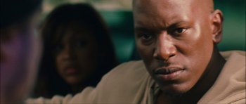 Movie still from “Waist Deep” (2006), directed by Vondie Curtis-Hall – A person sitting in front of another person; Close Up shot, Low angle
