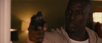 Movie still from “Waist Deep” (2006), directed by Vondie Curtis-Hall – A man holding a gun in his right hand; Close Up shot, Over the shoulder angle