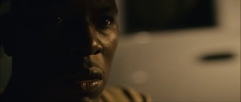 Movie still from “Waist Deep” (2006), directed by Vondie Curtis-Hall – A man's face in a dimly - lit room; Extreme Close Up shot, Over the shoulder angle