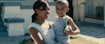 Movie still from “Waist Deep” (2006), directed by Vondie Curtis-Hall – A woman and a boy smiling for the camera; Medium shot, Over the shoulder angle