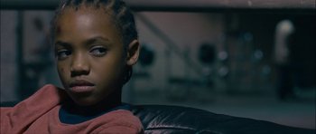 Movie still from “Waist Deep” (2006), directed by Vondie Curtis-Hall – A young boy sitting in a chair looking at the camera; Close Up shot, Low angle