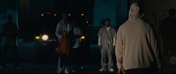 Movie still from “Waist Deep” (2006), directed by Vondie Curtis-Hall – A group of people standing on a street at night; Wide shot, Over the shoulder angle