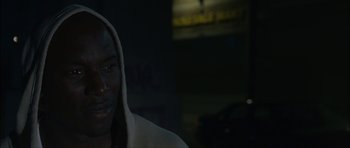 Movie still from “Waist Deep” (2006), directed by Vondie Curtis-Hall – A man in a hooded sweatshirt in the dark; Close Up shot, Over the shoulder angle