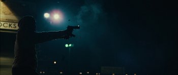 Movie still from “Waist Deep” (2006), directed by Vondie Curtis-Hall – A person holding a gun in the air at night; Medium shot, Low angle