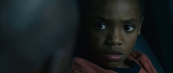 Movie still from “Waist Deep” (2006), directed by Vondie Curtis-Hall – A young boy's face with dark background; Close Up shot, Over the shoulder angle