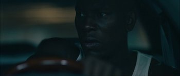 Movie still from “Waist Deep” (2006), directed by Vondie Curtis-Hall – A man's face in the dark; Close Up shot, Over the shoulder angle