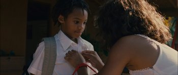 Movie still from “Waist Deep” (2006), directed by Vondie Curtis-Hall – A woman helping a young boy put on a tie; Close Up shot, Over the shoulder angle