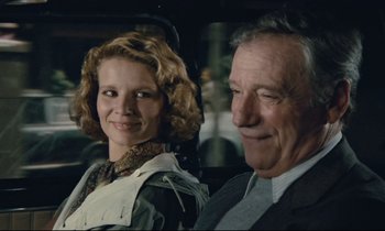 Movie still from “Waiter!” (1983), directed by Claude Sautet – A man and a woman sitting next to each other in a car; Close Up shot, Over the shoulder angle