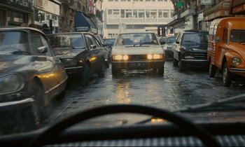 Movie still from “Waiter!” (1983), directed by Claude Sautet – A view from a car window of a busy city street; Wide shot, High angle