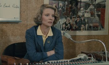 Movie still from “Waiter!” (1983), directed by Claude Sautet – A woman sitting in front of a keyboard; Medium shot, Low angle