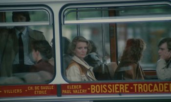 Movie still from “Waiter!” (1983), directed by Claude Sautet – A woman sitting on a bus looking out of the window; Medium shot, Over the shoulder angle
